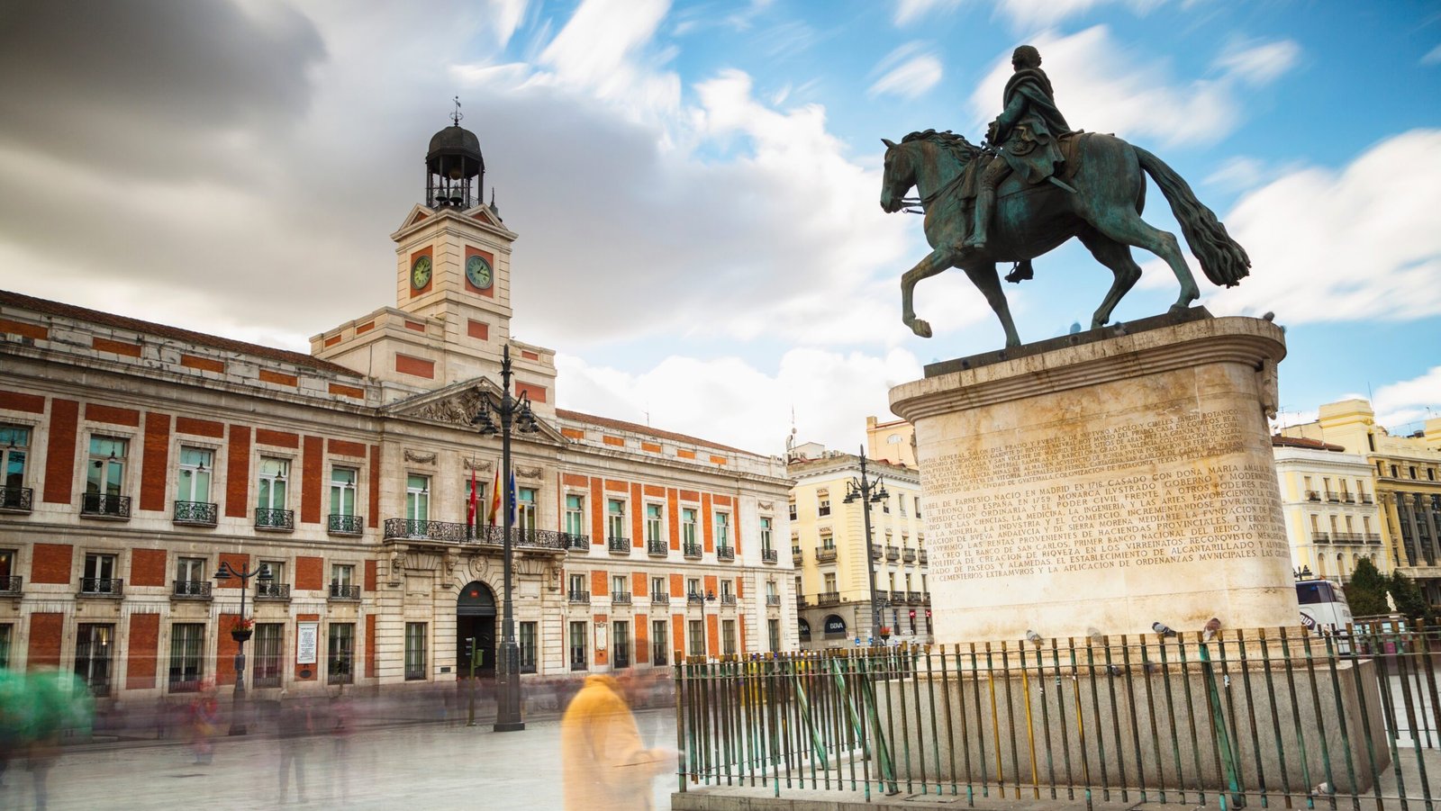 A statue of a person riding a horse in front of a building in Madrid, Spain