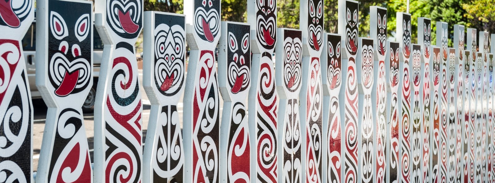 A fence with tradational Maori faces